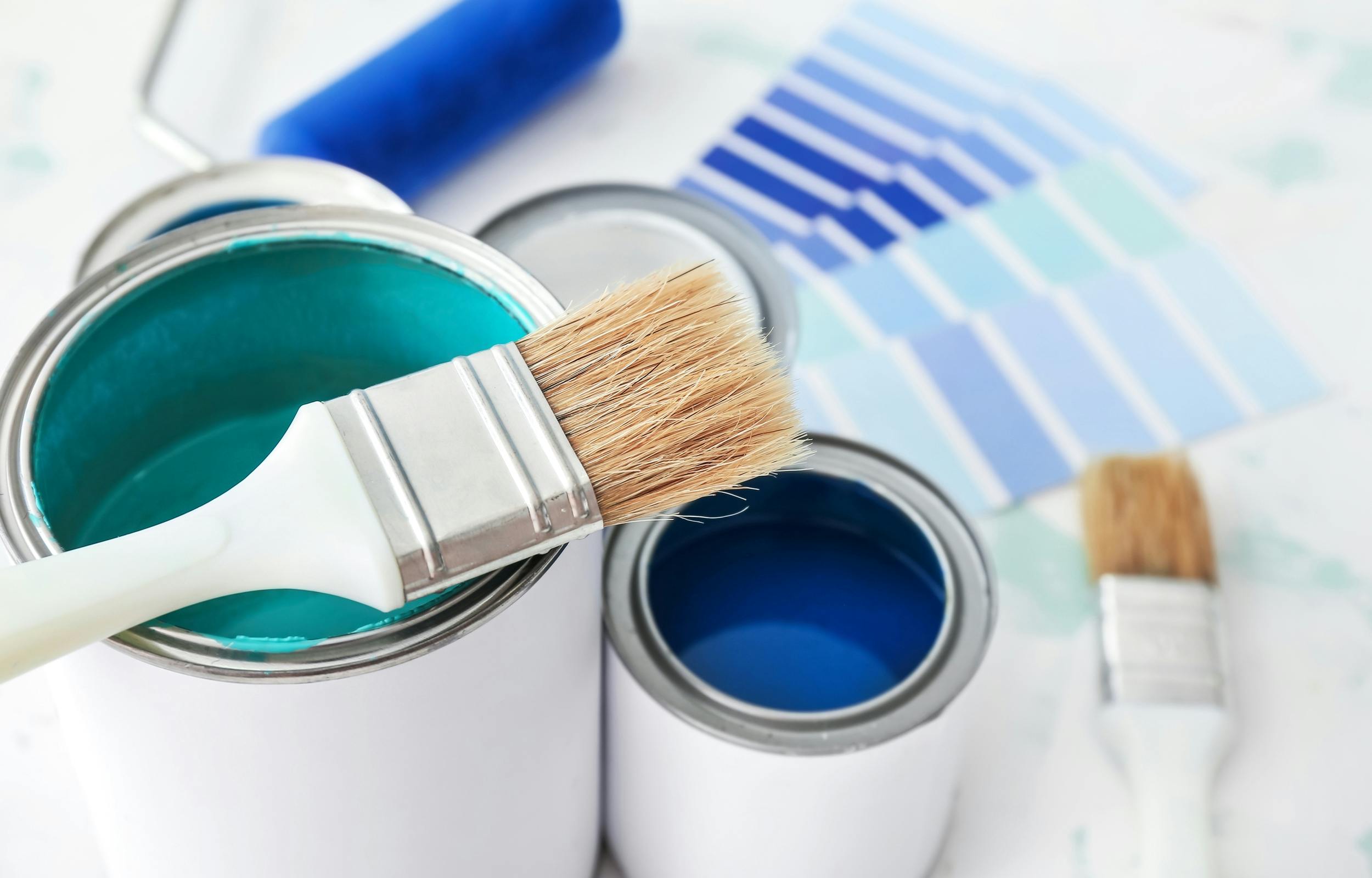 Vibrant indigo, turquoise, and green paint contrast stark white paint cans.  